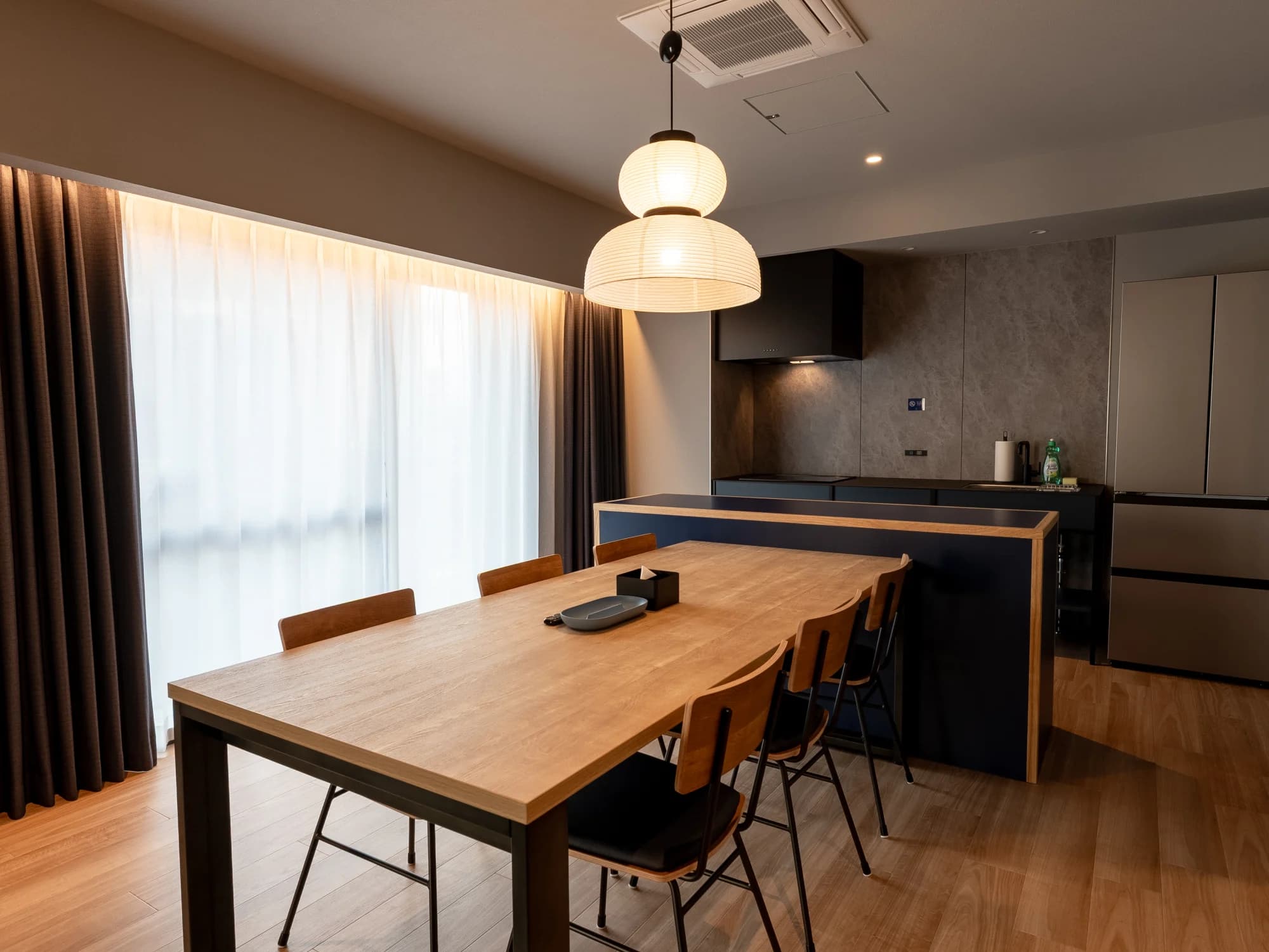 Group room with a dining table and kitchen